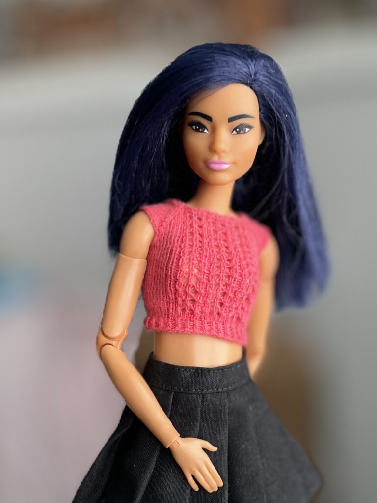 Barbie luciendo un top calado color coral tejido en hilo de algodón
