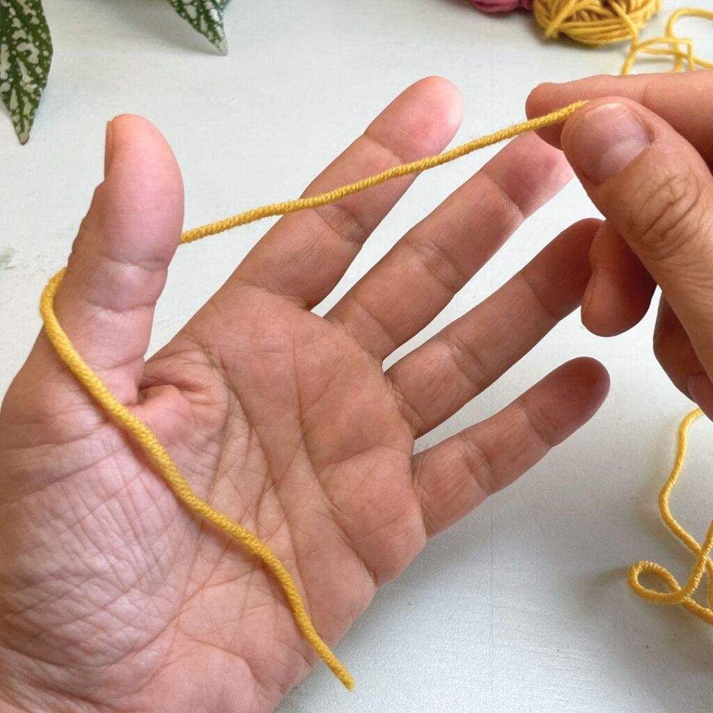 Segundo paso para el montaje de hebra larga: colocar la hebra tras el dedo pulgar