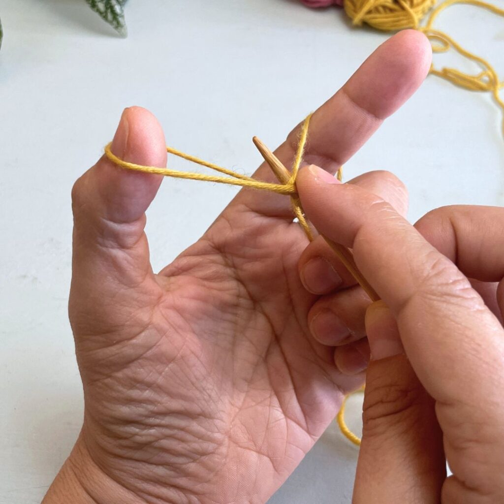 Pasa la aguja por debajo de la hebra y arrastra la hebra 