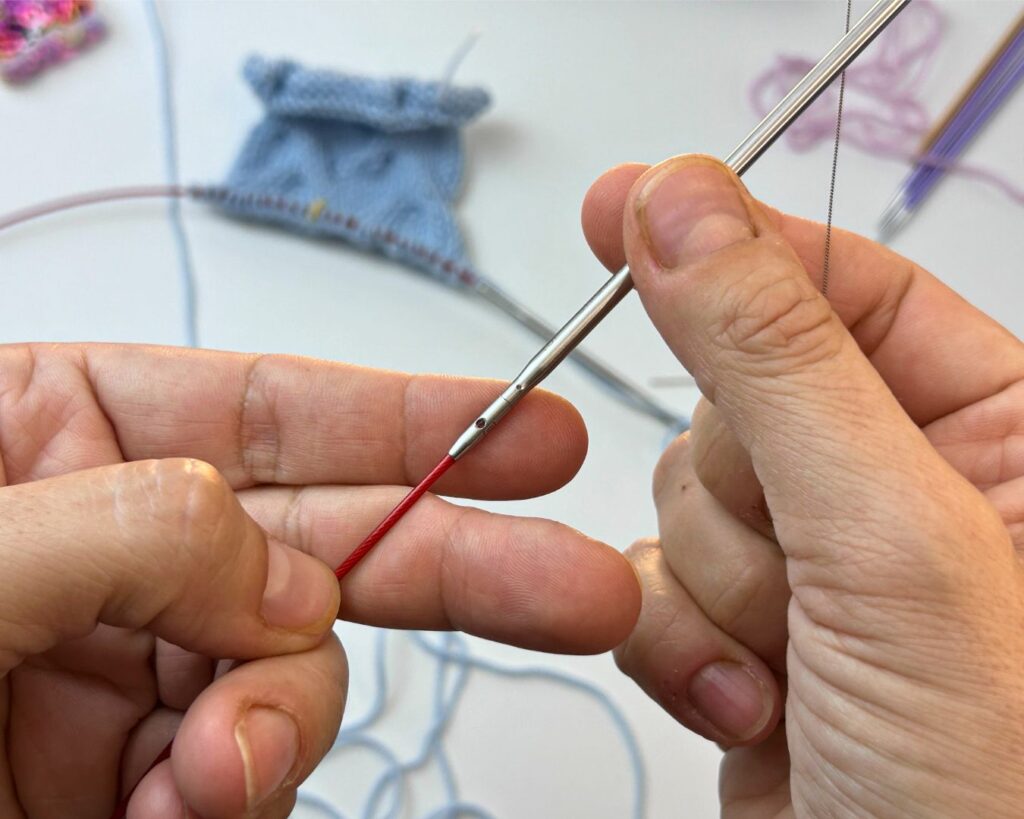 Algunas agujas intercambiables tienen un agujero en el cable que podemos utilizar para arrastrar el hilo a través de los puntos