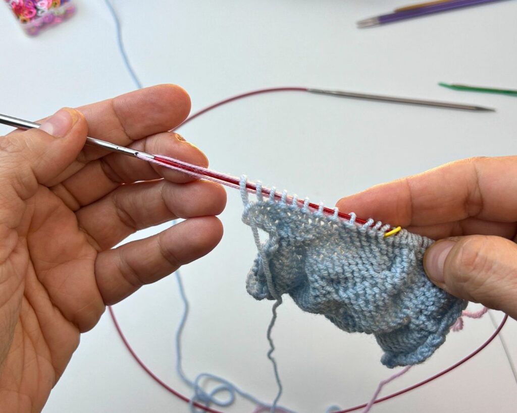 Al terminar la vuelta se extrae la aguja un poco para poder liberar el hilo y que se quede entre los puntos