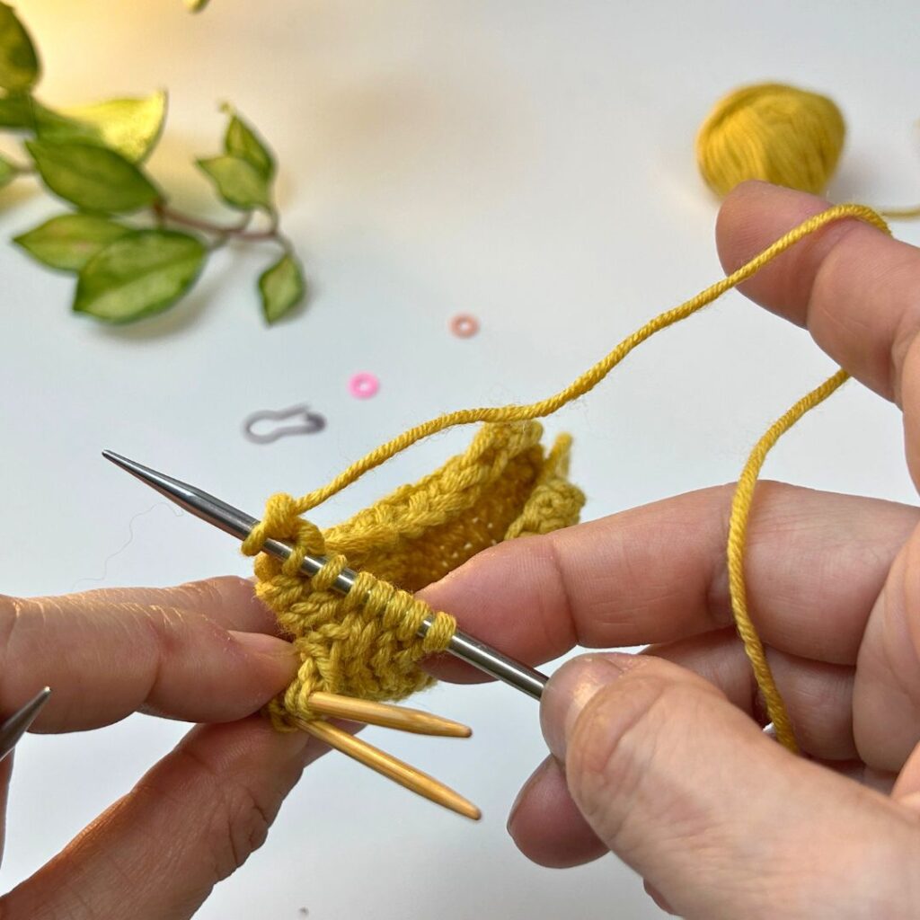 Seguir tejiendo el gorro dejando las orejas en espera